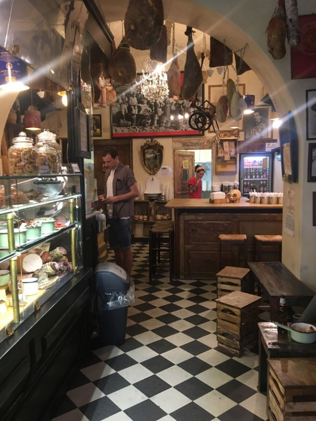 Interiér Cantina dei Papi v Trastevere s pultem sýrů a uzenin