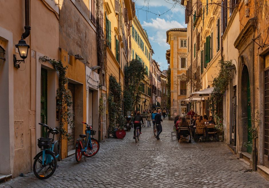 Úzká dlážděná ulička mezi barevnými domy v Trastevere.